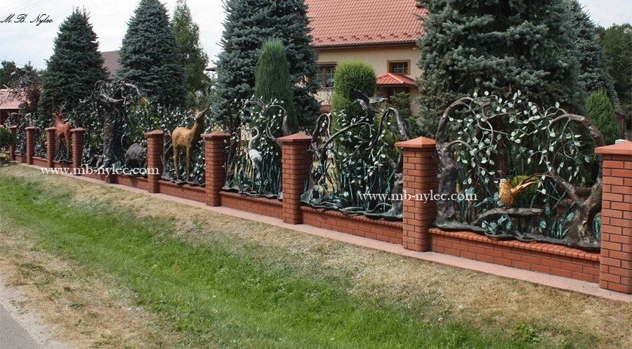 Kute ogrodzenie myśliwskie z figurami zwierząt między murowanymi słupkami